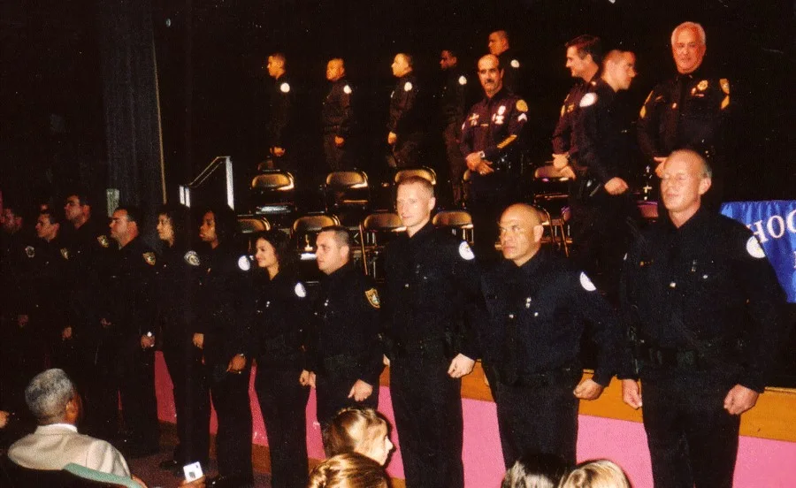 Police academy graduating class in dress uniform at a ceremony